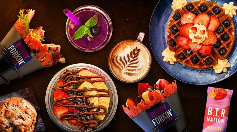 A flat lay of various Berry Forkin' Good desserts, including waffles, crepes, smoothie, and a cookie.